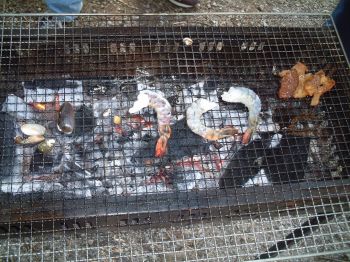 肉とエビと貝を焼いている様子